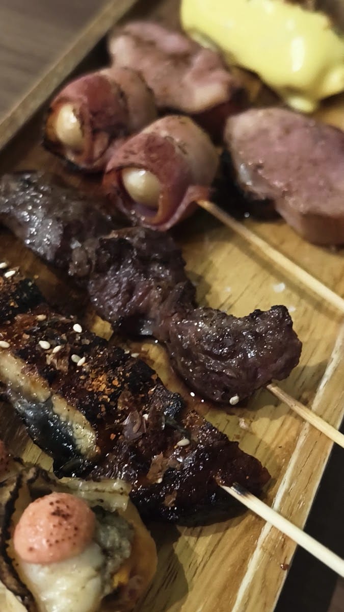 Grilled skewers lined up on a wooden tray